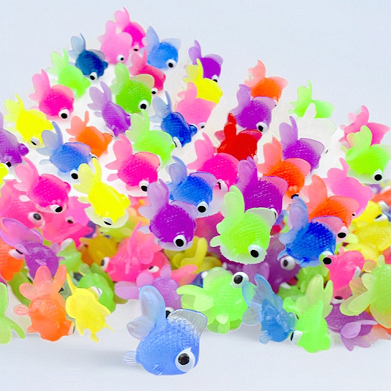 Цветная маленькая золотая рыбка плавает на воде, милый игрушечный золотой рыбка с большими глазами, летняя рыбалка маленькая игрушка